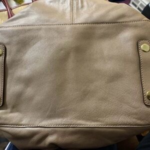 Woman Coach Satchel leather purse with strap.